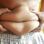 Fat guy holding is fat stomach